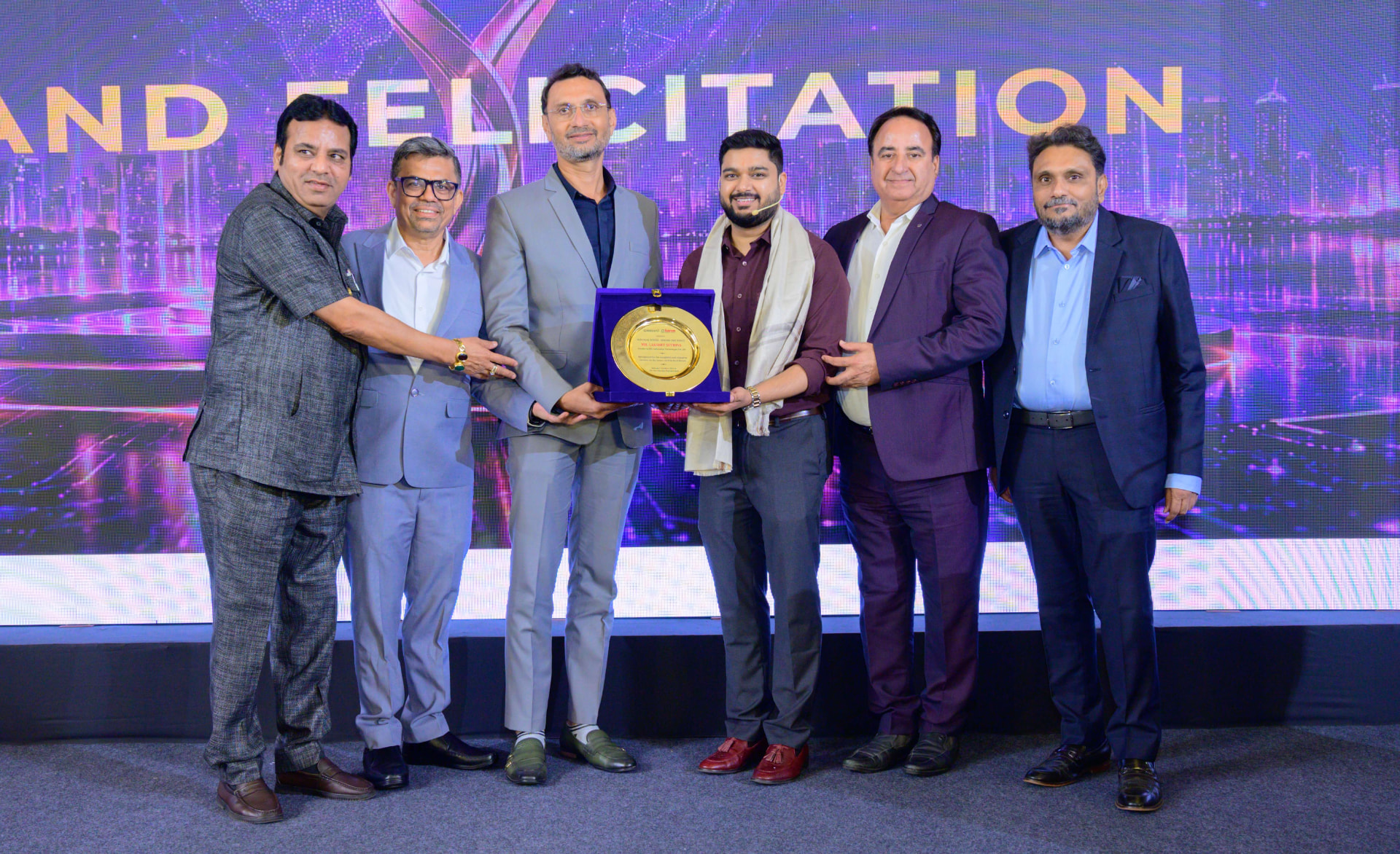 Lakshit Sethiya receiving an award on stage at the CREDAI BANM event